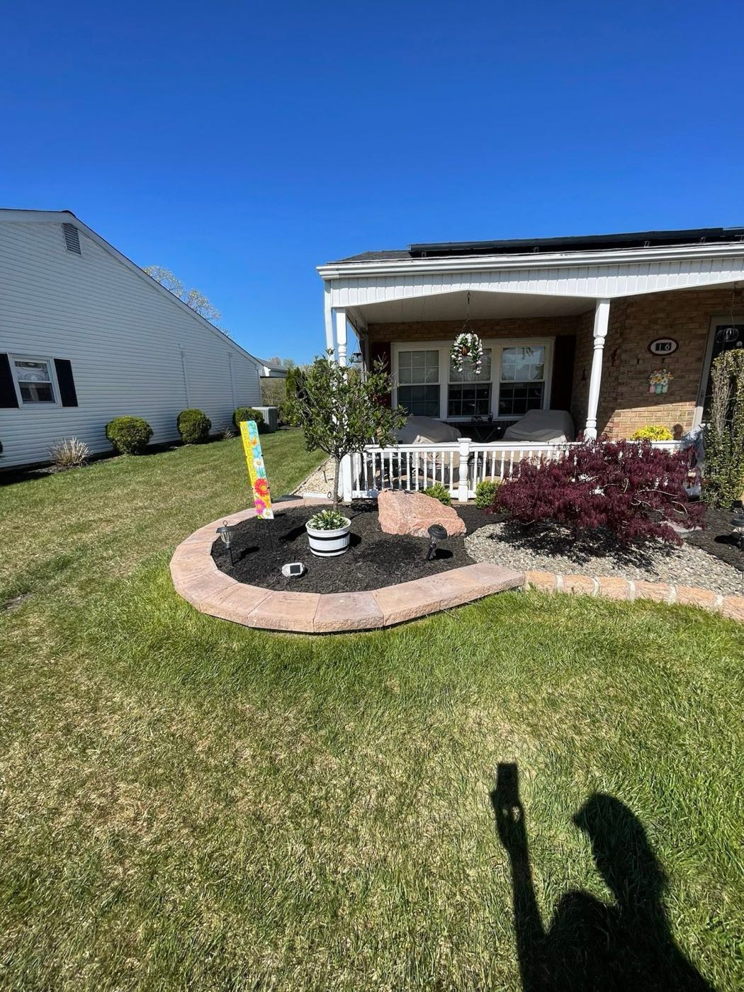 Island planting bed with stone edging and fresh mulch