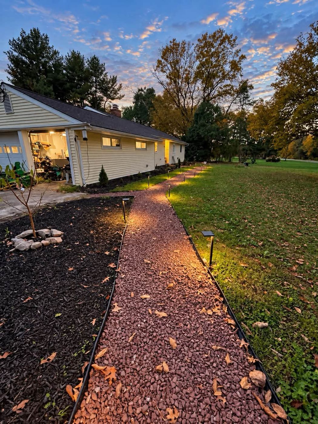 Crushed stone walkway with low-voltage path lights at dusk