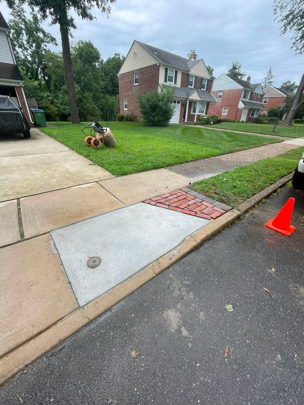 New concrete sidewalk section beside reset brick